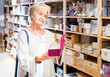 © JackF - Portrait of focused mature woman searching box for jewelry storage at store