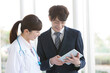© amanaimages - 打ち合わせをするビジネスマンと女医