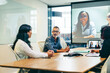 © Jacob Lund - Businesspeople having a virtual meeting with their partners in a boardroom