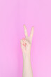 © Jun - hand showing number two In front of the pink background