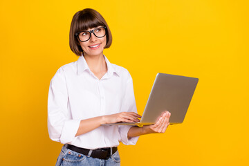 Canvas Print - Photo of dreamy freelancer lady hold laptop look empty space wear eyewear white shirt isolated yellow color background