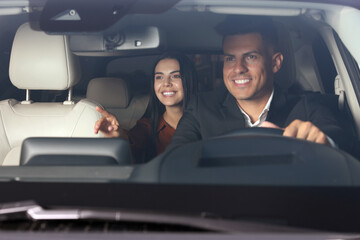 Poster - Young woman and taxi driver in modern car, view through windshield