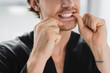 Cropped view of man in black robe cleaning teeth with dental floss