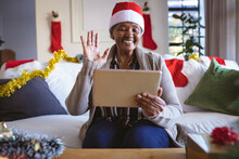 Happy African American Senior Woman In Santa Hat Making Tablet Christmas Video Call