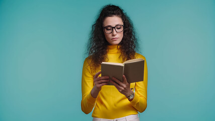 focused woman reading book isolated on blue