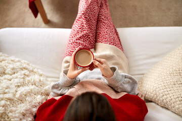Wall Mural - christmas, winter holidays and leisure concept - close up of young woman drinking coffee or hot chocolate at cozy home