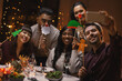 © Syda Productions - holidays, people and celebration concept - multiethnic group of happy friends with party props having christmas dinner at home and taking selfie with smartphone
