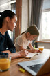 © Svitlana - Vertical shot of mom learn at home with small daughter