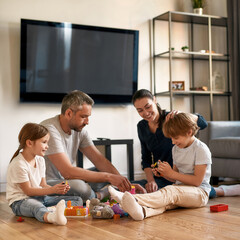 Wall Mural - Mom and dad play toys with kids