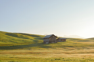 Beautiful view of the green field with a barn. Alpe di Siusi, Dolomites, Italy.