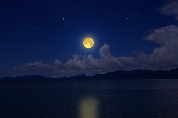 Wall Mural - Bright full moon over clouds and sea in the evening