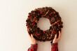 Female hands put Christmas wreath on wall. New Year's concept. View from above. Copy space.