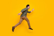 © deagreez - Full length body size profile side view of attractive cheerful man running fast isolated over bright yellow color background