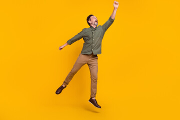Wall Mural - Full length body size view of attractive cheery dreamy man jumping holding copy space isolated over bright yellow color background