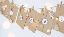 Hand Made Advent Calendar. Preparation To Christmas Concept. Craft Envelopes Arranged On A White Wall. Selective Focus.