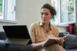 © Yakobchuk Olena - Female psychologist making notes with pleasure smile while holding video call