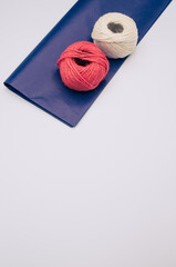 Poster - white and red decorative yarn balls on blue paper with stationery