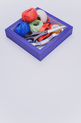 Poster - blue wooden box with multicolored  decoration yarn and stationery