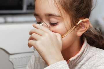 Little girl with a compressor inhaler mask on her face