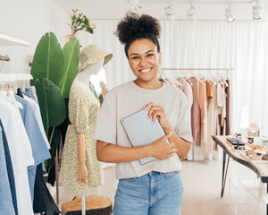 Wall Mural - Portrait of a happy woman manager in small fashion store holding a digital tablet and looking at camera