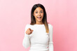© luismolinero - Caucasian girl isolated on pink background surprised and pointing front