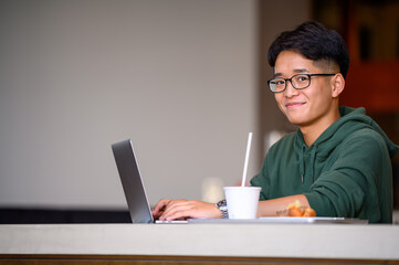 カフェでパソコン作業をする若者