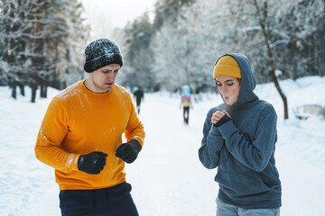 Wall Mural - Sportive couple during winter jogging in city park