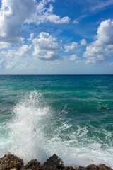 landscape of stormy Mediterranean sea with blue sky and white clouds and white sea foam off the coast of Turkey, Avsalar, Alanya during a storm in autumn