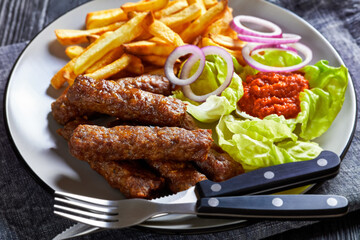 Sticker - cevapcici with potato fries, lettuce, onion, ajvar