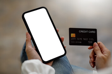  Close up hand of business Woman using a credit card and mobile smartphone for payments and online shopping, Online shopping, digital banking, E-commerce concept.