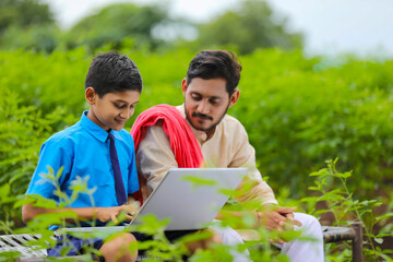 Poster - Education concept :cute indian school boy using laptop and giving some information to his father.