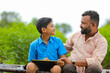 © Niks Ads - Cute indian farmer child studying with his father at home