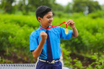 Wall Mural - Clever schoolboy showing medal as a winner in school competition.