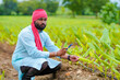 © Niks Ads - Indian farmer using smartphone at agriculture field