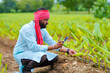 © Niks Ads - Indian farmer using smartphone at agriculture field
