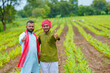 © Niks Ads - Young indian farmers showing thumps up at green turmeric agriculture field.