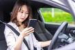 © maroke - スマホを使いながら車を運転する女性