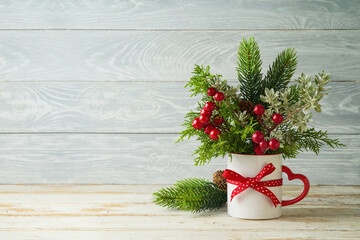 Wall Mural - Christmas pine tree branches in coffee cup on wooden table background