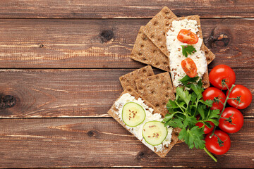 Poster - Crispbread with cream cheese, vegetables and green parsley on brown wooden table