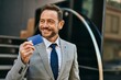 © Krakenimages.com - Middle age businessman smiling happy holding credit card at the city.