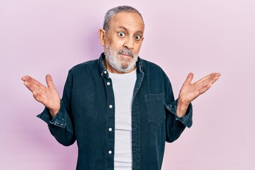 Canvas Print - Handsome senior man with beard wearing casual denim shirt clueless and confused with open arms, no idea and doubtful face.