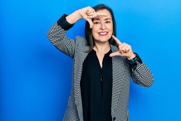 Canvas Print - Middle age hispanic woman wearing business clothes smiling making frame with hands and fingers with happy face. creativity and photography concept.