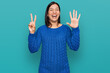 © Krakenimages.com - Young hispanic woman wearing casual clothes showing and pointing up with fingers number seven while smiling confident and happy.
