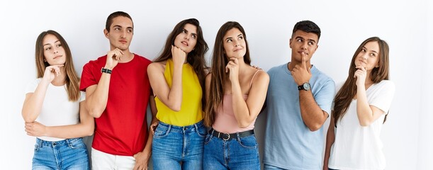 Wall Mural - Group of people wearing casual clothes standing over isolated background with hand on chin thinking about question, pensive expression. smiling with thoughtful face. doubt concept.