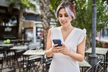 Poster - Young caucasian girl smiling happy using smartphone at the city.