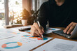 © Thapana_Studio - accounting concept. businessman working using a laptop with analyzing finance sales data and economic growth graph chart. at the coffee shop.