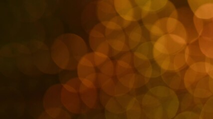 Wall Mural - Golden bokeh moves diagonally. Bright yellow-gold bokeh motion diagonally with a bright spot of light shimmering softly upward.