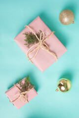 Gift boxes wrapped in pink kraft paper and tied with twine line on a blue background. Christmas concept