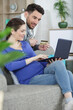 © auremar - couple with pregnant woman using laptop computer together