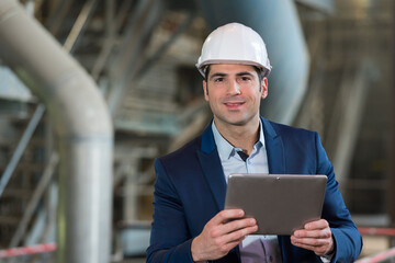 young male supervisor using tablet pc in industry